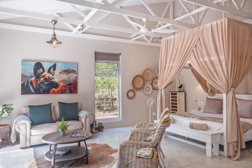 a bedroom with a bed and a couch and a table at Wild Honey Studio in Marloth Park