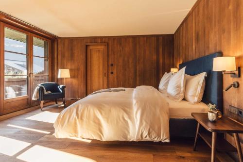a bedroom with a bed and a desk and a chair at Posthotel Taube in Schruns-Tschagguns