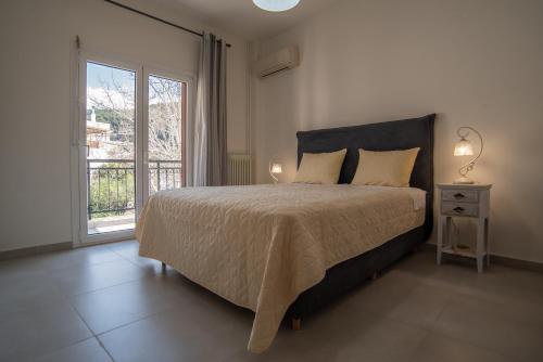 a bedroom with a large bed and a window at Karlovasi Comfy Retreat in Ríva