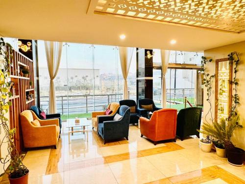 a living room with couches and chairs and windows at Shatha Abha Furnished Units in Abha