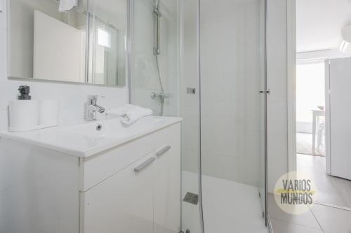 a white bathroom with a sink and a shower at Atico Calle Silva para 3pax con terraza esquina con Gran Via in Madrid