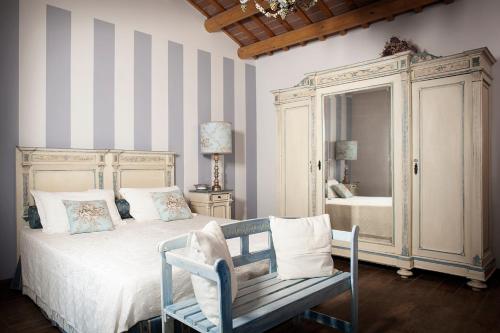 a bedroom with a bed and a chair and a mirror at Agriturismo Forzello in Ariano nel Polesine