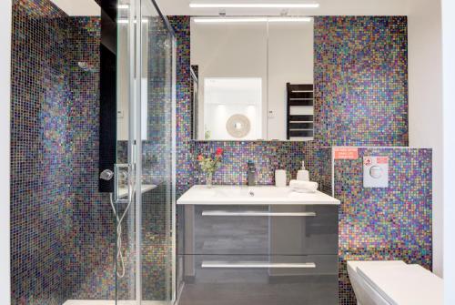 y baño con lavabo y ducha con mosaico de azulejos. en Cocoon in Cannes Sea View., en Cannes