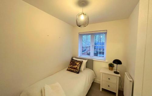 Habitación pequeña con cama y ventana en High Wycombe Stunning Stylish Four Bedroom House en High Wycombe