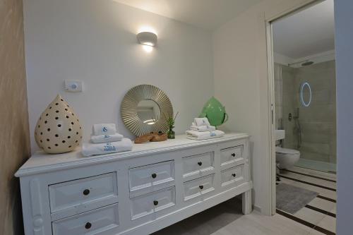 a white dresser in a bathroom with a mirror at Villa delle Sirene in Porto Cesareo