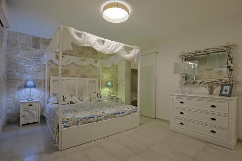 una camera con letto a baldacchino e cassettiera di Villa delle Sirene a Porto Cesareo