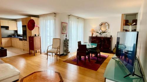 un salon avec une table en verre et une cuisine dans l'établissement Chez Nicole & Denis, à Boulogne-Billancourt