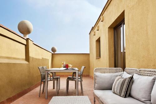 a patio with a couch and a table and chairs at Barcelona Apartment Milà in Barcelona