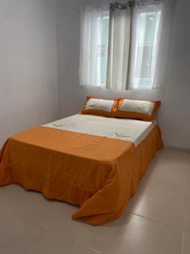a bed in a white room with a window at Pousada da Vovó Ideni Nova Tramandaí in Tramandaí