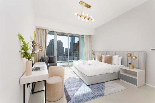 a white bedroom with a bed and a living room at Lavish Living in Dubai Marina's Finest 2 bedroom in Dubai