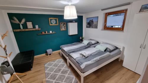 a bedroom with a bed and a green wall at Ruhige, modern eingerichtete 2 Zimmer Wohnung im Untergeschoss eines Zweifamilienhauses in Hildrizhausen