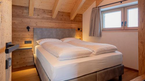 a large bed in a room with a window at Chalet Aria Pura in Livigno