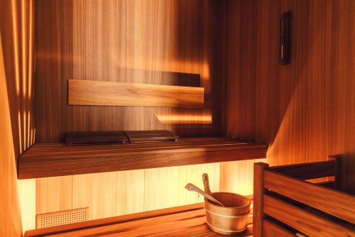 a wooden shelf in a sauna with a pot at Posthotel Taube in Schruns-Tschagguns