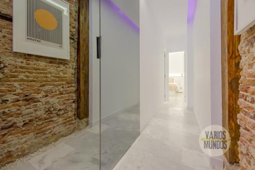 a hallway with a glass door and a brick wall at Cool Duplex Bajo Apt 7pax cerca de Tirso de Molina in Madrid