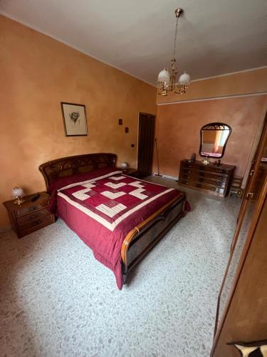 una camera con un grande letto e un lampadario a braccio di Central House a Castel di Sangro