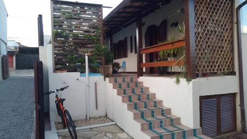 a bike parked next to a building with stairs at Ramos Acomodações in Búzios