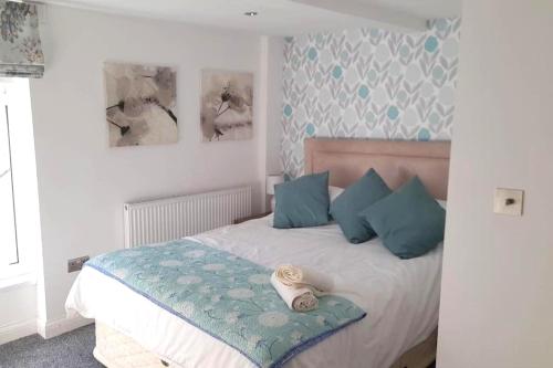 1 dormitorio con 1 cama con almohadas azules en 6 Eden Bay for 7 guests en Morecambe
