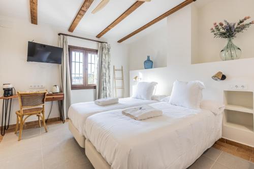 a bedroom with a large white bed and a desk at Hospedium Hotel Rural Virgen María in Castilblanco de los Arroyos