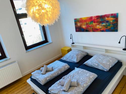 een slaapkamer met 2 bedden en een kroonluchter bij SECRET HIDEAWAYS Design Apartment ARTstudio 5 nahe City l Messe l Hbf in Duisburg