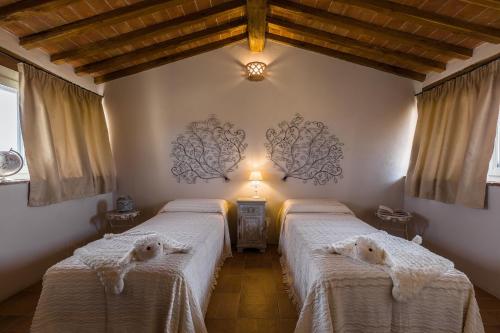 ein Schlafzimmer mit 2 Betten und weißen Decken darauf in der Unterkunft Casale La Rugantina in Cortona