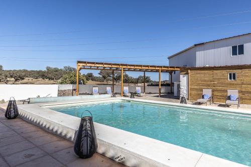 einen Pool mit Stühlen und ein Gebäude in der Unterkunft Hotel Rural Ganadería Virgen María in Sevilla