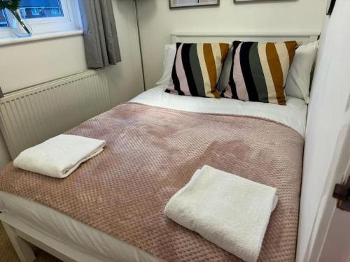 uma pequena cama num quarto com duas toalhas em Summer House Sleeps 6 , 2 Large Parking Spaces, walking distance to Cardiff Bay and City Centre em Cardiff