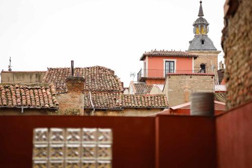 uma vista sobre os telhados de uma cidade com uma torre do relógio em 33 Pasos Catedral 1 em León