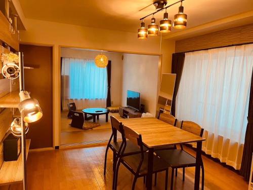 a living room with a table and chairs and a dining room at HS平岸 HSHiraghishi in Minami-jūichijō
