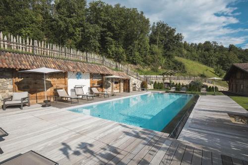 a swimming pool with a wooden deck and a house at Apartments Pitschlmann in Fiè