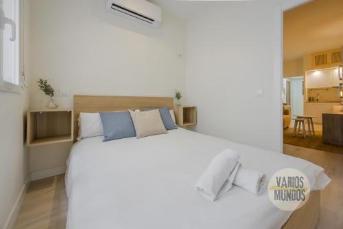 1 dormitorio blanco con 1 cama blanca grande con almohadas en Cozy Apt 1hab para 4 pax en la Plaza de Chueca, en Madrid