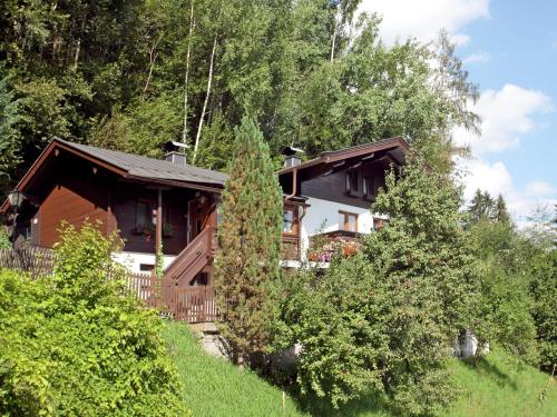 una casa en una colina con árboles delante de ella en Apartment in Stuhlfelden with terrace, en Stuhlfelden