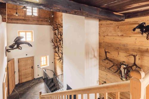 a room with wooden walls and a staircase with animals on the wall at Posthotel Taube in Schruns-Tschagguns
