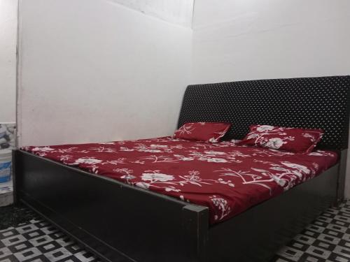 uma cama com lençóis vermelhos e almofadas vermelhas em KIRTI SEVA SADAN em Mathura