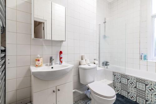 a white bathroom with a toilet and a sink at LiveStay Cozy One Bedroom Apartment in Brixton in London
