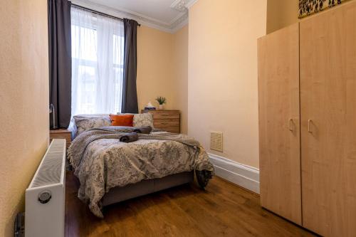 a bedroom with a bed and a large window at LiveStay Cozy One Bedroom Apartment in Brixton in London