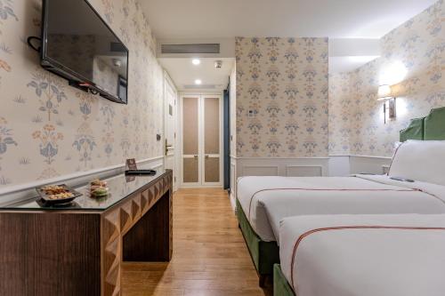 a hotel room with two beds and a table at Khai Karaköy in Istanbul