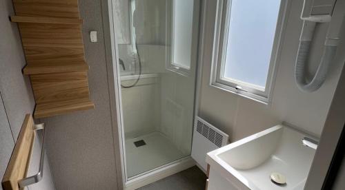 La petite salle de bains est pourvue d'une douche et d'un lavabo. dans l'établissement Camping les Portes du Perche, à Mamers