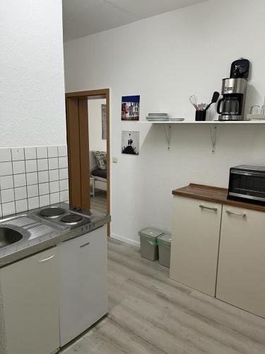 a kitchen with white cabinets and a counter top at Pension Christianstraße in Bernburg