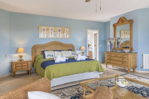 - une chambre avec un grand lit et un miroir dans l'établissement La Manga Club Resort - Individual Villa 439, à Atamaría