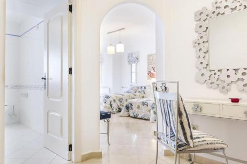 une chambre blanche avec une chaise et une chambre dans l'établissement La Manga Club Resort - Individual Villa 439, à Atamaría