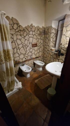 a stone bathroom with two toilets and a sink at Tenuta Oliva in Fisciano