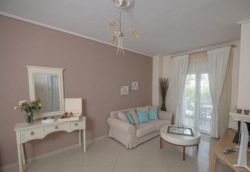 a living room with a couch and a table and a mirror at Nereides Luxury Villas in Káto Almirí