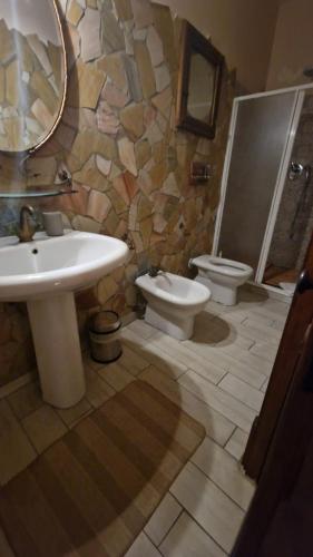a bathroom with two toilets and a sink and a mirror at Tenuta Oliva in Fisciano