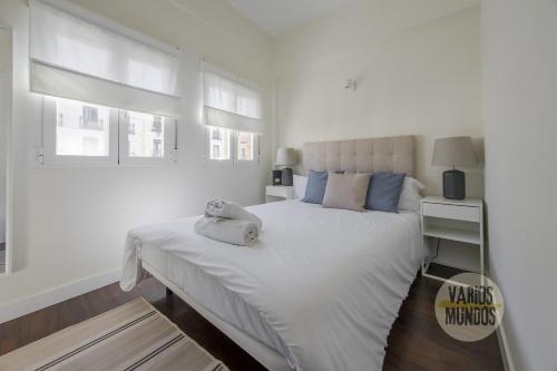 a white bedroom with a large white bed and windows at New Loft 1hab 3px en plena Plaza de Chueca in Madrid