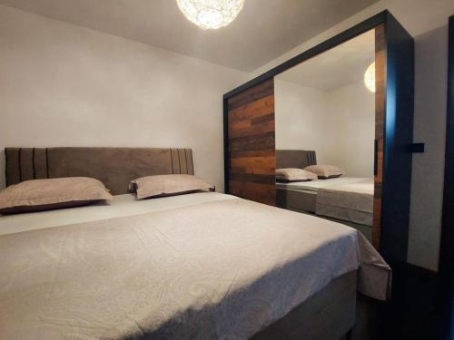 een slaapkamer met een groot bed en een spiegel bij B&B Onyx in Sisak