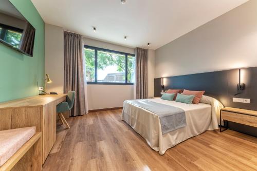 a hotel room with a bed and a window at Hotel Villa Universitaria in San Vicente del Raspeig