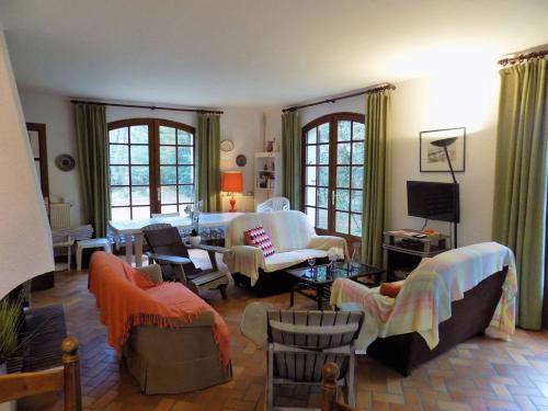 a living room with a bed and chairs at La Palmyre - MAISON INDIVIDUELLE - PARC de la RESIDENCE - WIFI in Les Mathes