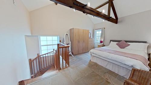 a bedroom with a large bed and a staircase at The Barn. in Carmarthen