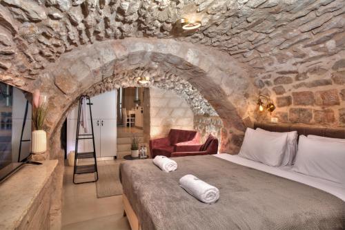 - une chambre avec un grand lit dans un mur en pierre dans l'établissement סוויטת גן עדן - Gan Eden Suite, à Safed