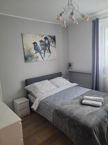 a bedroom with a bed and a painting on the wall at Apartament pod szczęśliwą 13 in Toruń